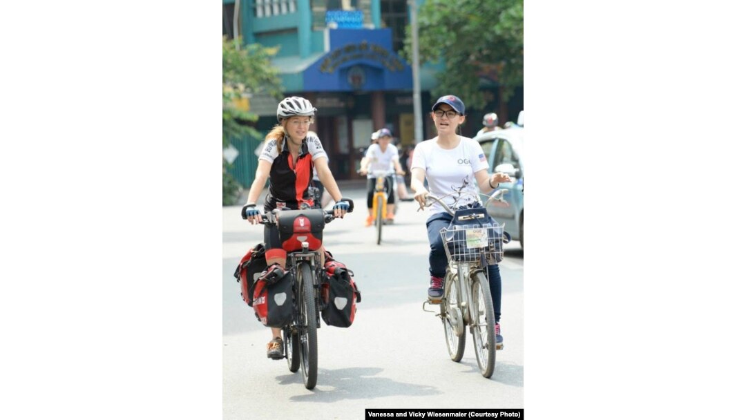 Vicky Wiesenmaier chats with a Vietnamese woman during a ride in Hanoi.