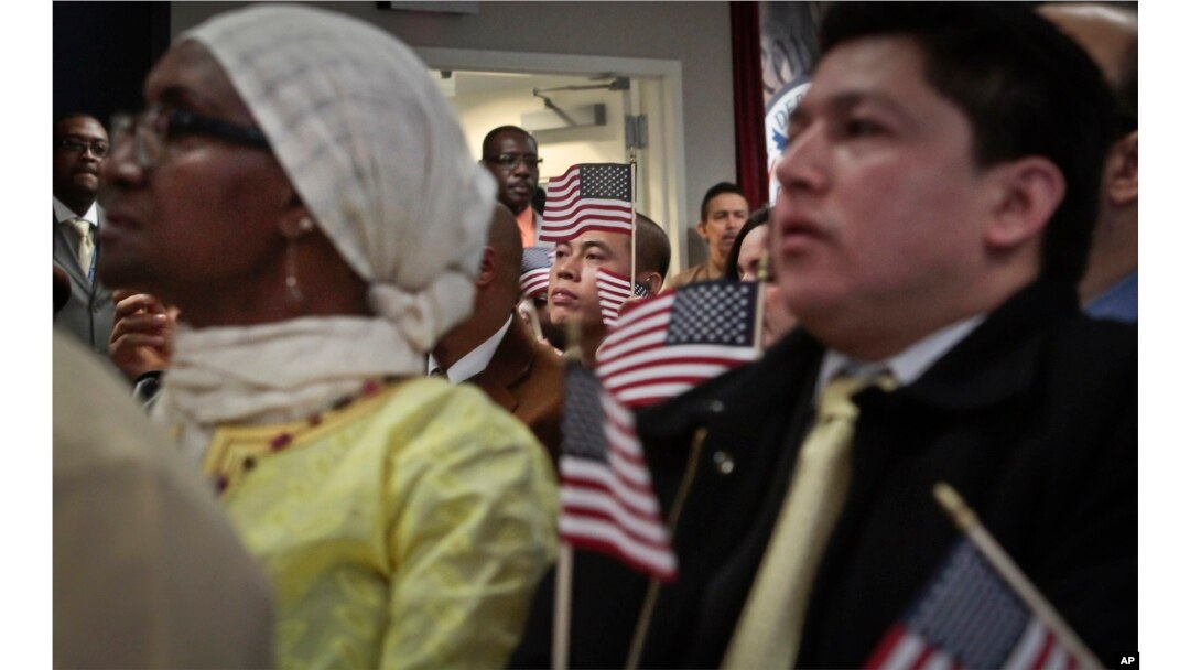 FILE - Immigrants hold miniature U.S. flags during a naturalization ceremony in New York. In a major shift in immigration patterns over the next 50 years, While Europeans dominated immigration in the 1910s, as Latin Americans did after 1970, Asians are now the latest and largest wave of newcomers to the United States, the Brookings Institution reported.
