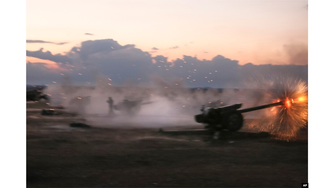In this photo taken on Oct. 7, 2015, Syrian army howitzers fire near the village of Morek in Syria.