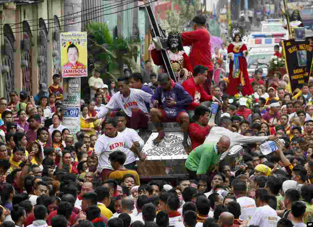 Filipino Catholic devotees jostle to get closer to the image of the Black Nazarene during a procession on New Year's eve in Manila, Philippines, Dec. 31, 2015.