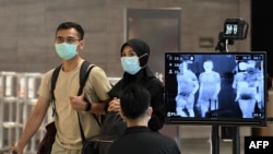 지난 27일 싱가포르 창이 국제공항에서 신종 코로나바이러스 방역을 위해 여행객들의 체온을 재고 있다.