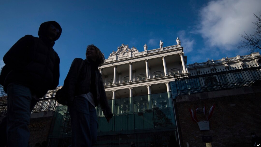 FILE - People walk past Palais Coburg, where closed-door nuclear talks take place in Vienna, Austria, Dec. 17, 2021.