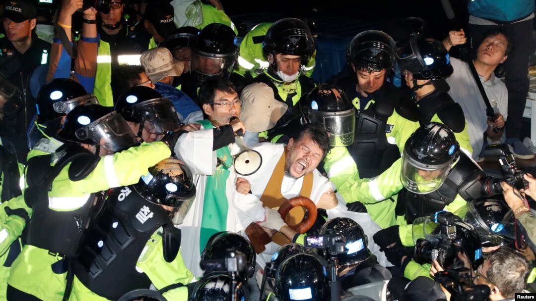 People scuffle with riot police during a protest opposing the deployment of a Terminal High Altitude Area Defense (THAAD) system in Seongju, South Korea, Sept. 7, 2017.