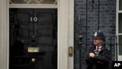 A police officer stands guard outside the door of 10 Downing Street in London, June 7, 2019. 