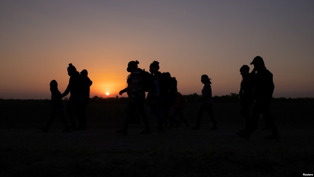 Migrantes de El Salvador y Honduras caminan hacia el muro fronterizo después de cruzar el río Grande, en Penitas, Texas, el 26 de marzo de 2021.