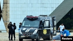 Agentes da Polícia Civil brasileiram retira corpo do autor de atentado suicida contra a Praça dos Três Poderes em Brasília, Brasil, 13 novembro 2024