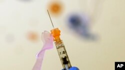 FILE - Nurse Lydia Holly prepares a child's COVID-19 vaccine dose, on Nov. 3, 2021, at Children's National Hospital in Washington.
