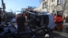 Afghan security personnel and municipality workers remove a damaged vehicle after a roadside bomb attack in Kabul, Dec. 22, 2020. 
