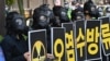 South Korean environmental activists wearing gas masks hold placards during a protest against Japan's decision to discharge Fukushima wastewater into the sea, near the Japanese Embassy in Seoul, June 4, 2021, a day before World Environment Day.