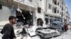 FILE - Syrians gather at a site of car bomb in the northwestern Syrian city of Idlib, Aug. 2, 2018. 