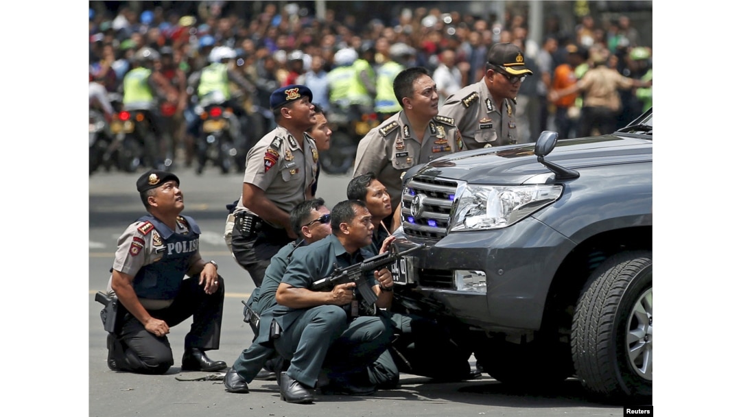 Police officers react near the site of a blast in Jakarta, Indonesia, Jan. 14, 2016.