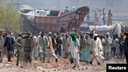 Supporters of the banned Islamist political party Tehreek-e-Labbaik Pakistan (TLP) with sticks and stones block a road during a protest in Lahore, Pakistan, Apr. 18, 2021. 