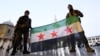 Rebel fighters pose as they hold a Syrian opposition flag inside the Umayyad Mosque, after rebels seized the capital and ousted Syria's Bashar al-Assad, in Damascus, Syria December 9, 2024.