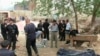 Police and government officials stand near the bodies of victims following a bloody clash in Bachu, Xinjiang, April 23, 2013. 