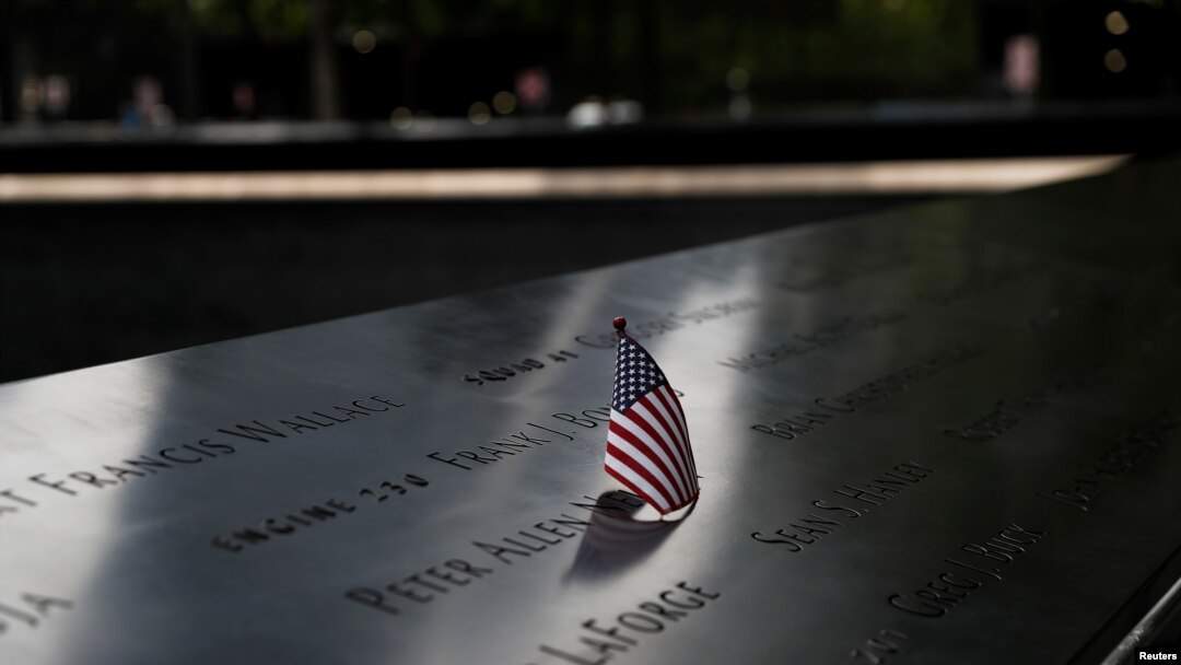 Una bandera estadounidense es colocada en uno de los nombres en la fuente reflectante en el Monumento conmemorativo del 11 de Septiembre en la ciudad de Nueva York.
