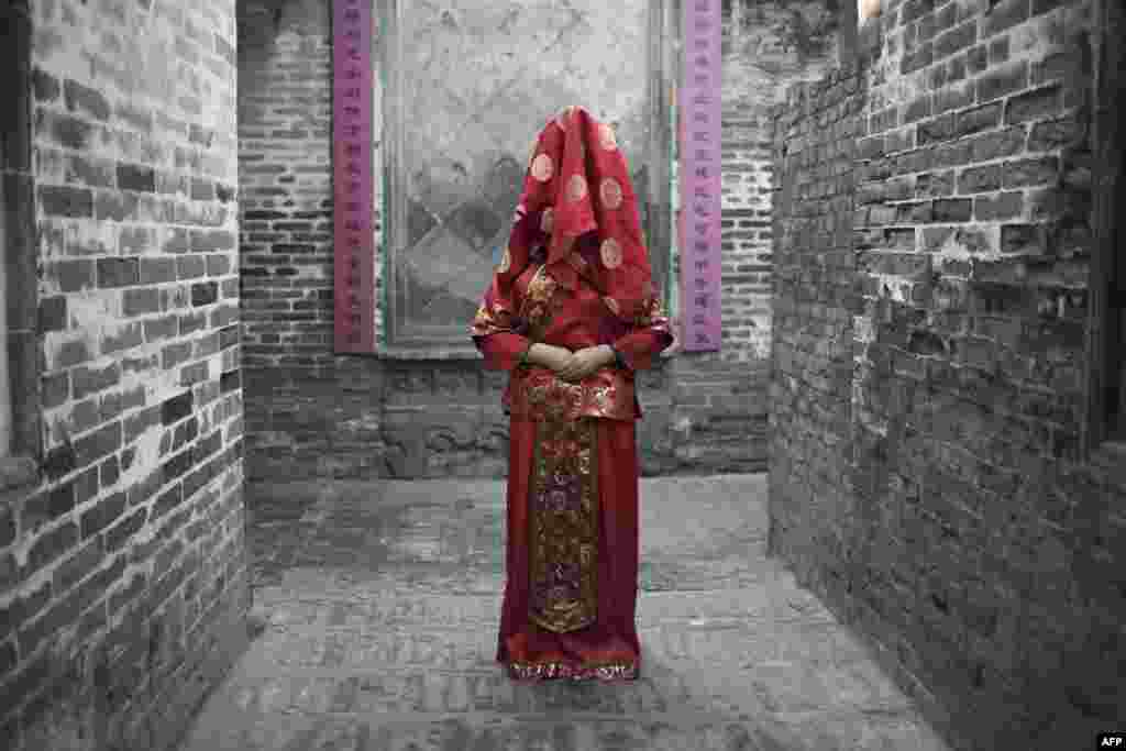 一位穿着中国传统婚服的女性在陕西韩城的社火节上进行婚礼表演，以庆祝农历狗年的到来。照片拍摄于2018年2月16日。