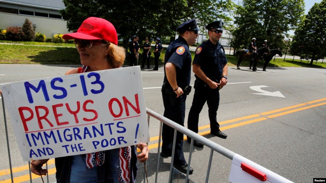 Archivo - Una simpatizante del presidente de Estados Unidos, Donald Trump, sostiene un cartel que dice que la MS-13 caza a inmigrantes y pobres, en un evento realizado en Bethpage, Nueva York en mayo 23, 2018.
