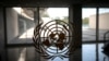 FILE - The United Nations logo is seen on a window in an empty hallway at United Nations headquarters in New York.