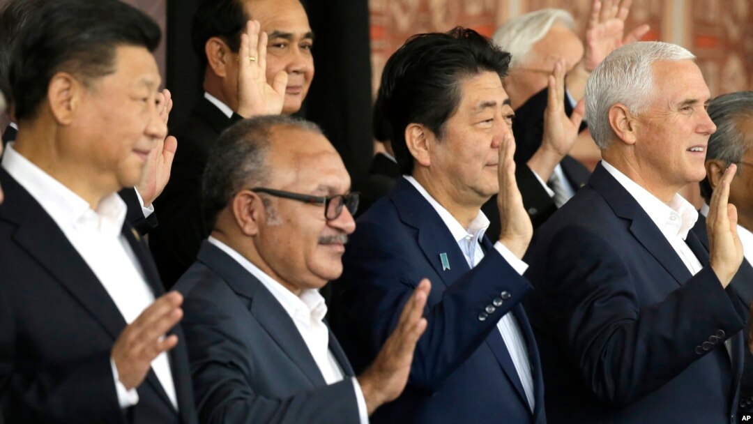 From left, Chinese President Xi Jinping, Papua New Guinea's Prime Minister Peter O'Neill, Japanese Prime Minister Shinzo Abe, and U.S. Vice President Mike Pence wave as they pose for a group photo at APEC Haus in Port Moresby, Papua New Guinea, Nov. 18, 2018.