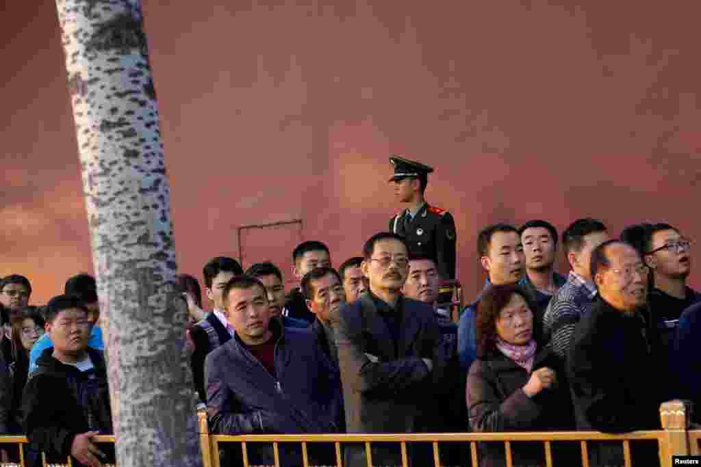 中共十九大举行之际,人们排队等待进入北京天安门广场,旁边有武警站岗(2017年10月22日)
