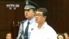 Chongqing municipality ex-police chief Wang Lijun (R) reads a statement during his sentencing inside the courtroom of the Chengdu People's Intermediate Court in Sichuan province in this still image taken from video, Sept. 24, 2012. 
