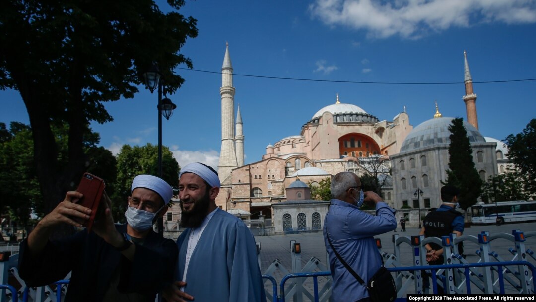 Personas se toman un selfie afuera de la cerra catedral de la era bizantina, Hagia Sophia, una de las principales atracciones turísticas de Estambul. Julio 11 de 2020.
