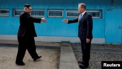 FILE - South Korean President Moon Jae-in and North Korean leader Kim Jong Un, left, are about to shake hands on their first meeting at the truce village of Panmunjom inside the demilitarized zone separating the two Koreas, South Korea, April 27, 2018. 