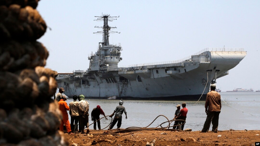 Indian navy's first aircraft carrier the INS Vikrant is drawn closer to shore at Darukhana ship breaking yard in Mumbai, India, Saturday, May 31, 2014.