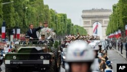 FILE - France's President Emmanuel Macron and French Armies Chief Staff General Francois Lecointre review troops before the start of the Bastille Day military parade down the Champs-Elysees avenue in Paris, July 14, 2019. 