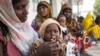 FILE - A woman feeds her child at a clinic in a rural village in Afar, Ethiopia, Jan. 26, 2016.