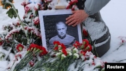 A portrait of Russian military blogger Vladlen Tatarsky, who was killed in the cafe explosion the day before, is placed near the blast site in Saint Petersburg
