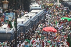 Algerian riot policemen stand guard as protesters gather during a weekly demonstration coinciding with the Algerian independence day in Algiers, July 5, 2019.