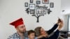Mohamad Bassel Khair, left, holds his son, Sami Kahir, 2, as his wife Lama Alassil takes a photo of them to post on the Snapchat application during a photo session with The Associated Press in his home in Clifton, N.J. Khair, of Damascus, Syria, is graduating from New Jersey's Montclair State University with a master’s in nutrition and food science and is now seeking asylum in the U.S. for his family. 