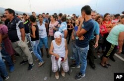 People line up to receive bags with food subsidized by the Nicolas Maduro's government near the international bridge of Tienditas on the outskirts of Urena, Venezuela, Feb. 11, 2019.