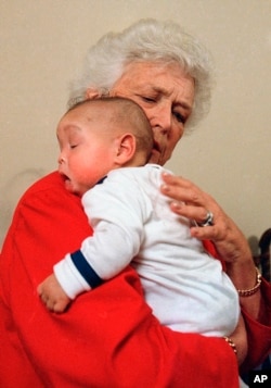 FILE - In this March 22, 1989, file photo, former first lady Barbara Bush holds an infant identified as Donovan during a visit to Grandma’s House in Washington. Grandma’s House provided residential care for abandoned infants and young children living with HIV/AIDS.