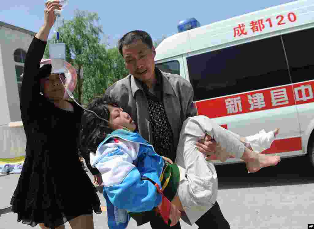 A man carries an injured woman to a temporary treatment station following an earthquake in Lushan county in Ya'an in southwest China's Sichuan province, Apr. 20, 2013.