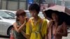 A Chinese family eats ice cream to stay cool as high temperatures continue in Beijing, August 6, 2013.