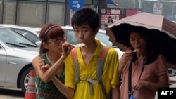 A Chinese family eats ice cream to stay cool as high temperatures continue in Beijing, August 6, 2013.