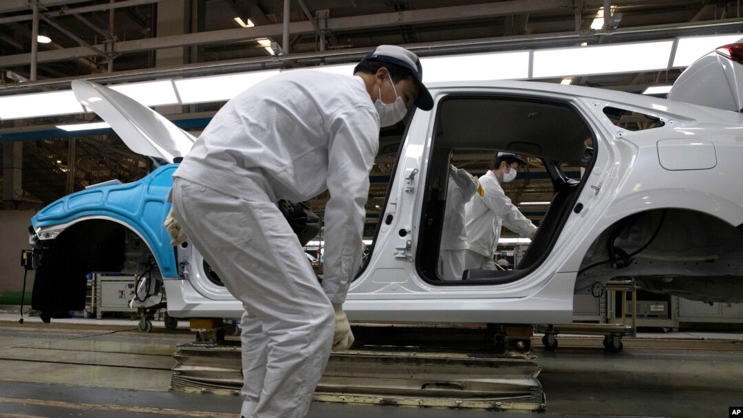 FILE - In this April 8, 2020, photo, employees work on a car assembly line at the Dongfeng Honda Automobile Co., Ltd factory in Wuhan in central China's Hubei province. 