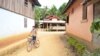 FILE - A boy rides his bicycle through Houaygno village, northern Laos, Nov. 4, 2019. 