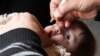 A health worker administers polio vaccination to a child in Raqqa, eastern Syria, Nov. 18, 2013.