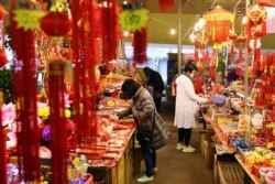 FILE - People wearing masks to protect against the coronavirus shop ahead of the Lunar New Year holiday, in Taipei, Taiwan, Feb. 9, 2021.