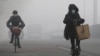 People ride amid the smog in Beijing, China, Feb. 14, 2017. 