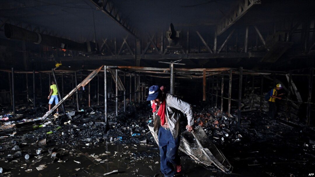 La gente saca elementos de una tienda incendiada el día después de las protestas contra el gobierno del presidente colombiano Iván Duque, en Cali, Colombia, el 29 de mayo de 2021.