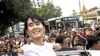 Burma's pro-democracy leader Aung San Suu Kyi greets supporters as she leaves her National League for Democracy party following her meeting with newly elected lawmakers at the party headquarters in Rangoon, April. 7, 2012.