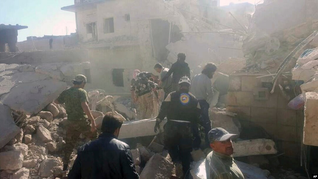 This photo provided by the Syrian Civil Defense White Helmets, which has been authenticated based on its contents and other AP reporting, shows Civil Defense workers and Syrian citizens inspecting damaged buildings after airstrikes hit in Darat Izza town, in rural western Aleppo province, Syria, Saturday, Nov. 5, 2016.