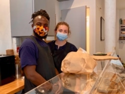 Nigerian Bosun Ola and his partner Fay Latham recently opened the trendy Ola's Cafe, offering another changing face of Goutte d'Or, in Paris. (Lisa Bryant/VOA)