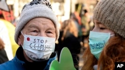 FILE - Climate activists attend the March for Climate in a protest against global warming in Katowice, Poland, Saturday, Dec. 8, 2018, as the COP24 UN Climate Change Conference takes place in the city.