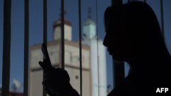 Loubna, msichana wa Morocco mwenye umri wa miaka 18 aliyelengwa na unyanyasaji wa mitandao akitumia simu yake mji wa mwambao wa Casablanca Machi 9, 2020. (Photo by FADEL SENNA / AFP)-