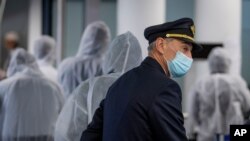 FILE - A pilot and crew members of South African Airways go through the security check in Frankfurt, Germany, April 18, 2020.